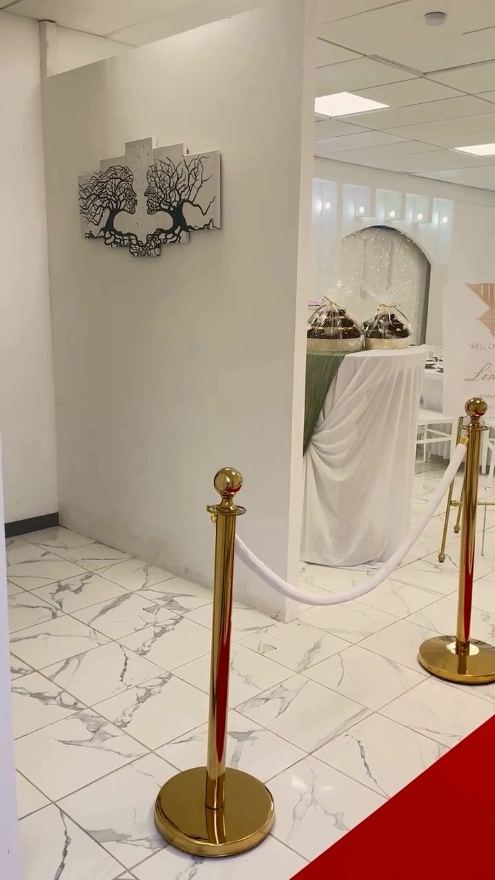 Table d'accueil drapée de blanc et de vert avec des paniers cadeaux pour les invités